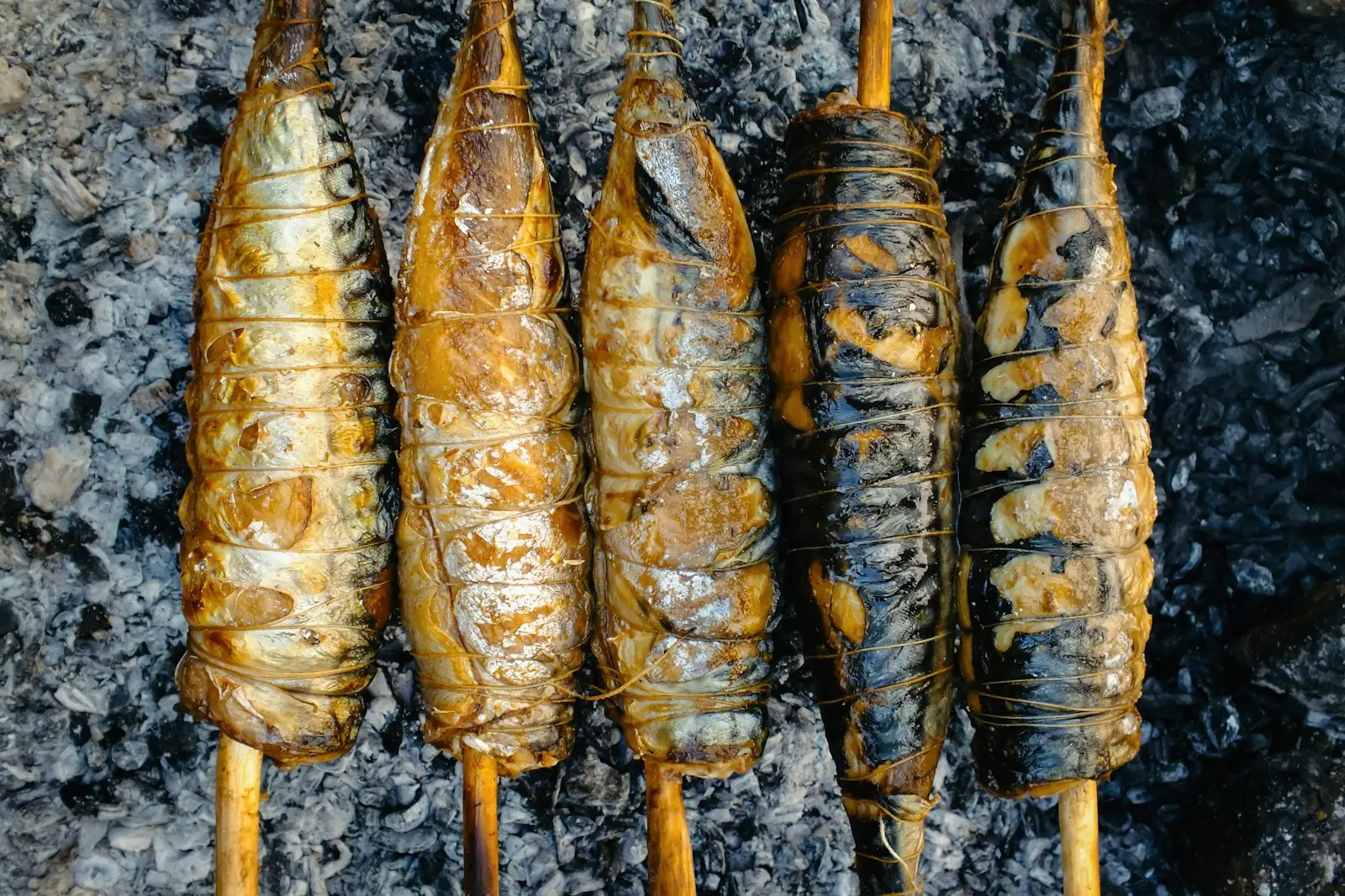 Espeto di sardine che arrostiscono sulla brace: il posto giusto per mangiarli sono i chiringuitos di Pedregalejo